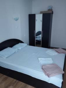 a bedroom with a large white bed with a mirror at apartment DIAMOND SARAFOVO in Burgas City