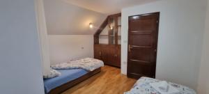 Dormitorio pequeño con 2 camas y armario en ANNA, en Žabljak