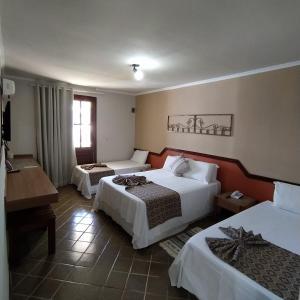 um quarto de hotel com duas camas e um piano em Granville Eco Resort em Rio de Contas