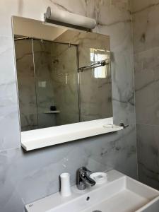 y baño con lavabo y espejo. en Menikos Apartments, en Himare