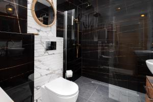 Un baño con inodoro, lavabo y espejo. en Cały apartament z Victorian wanna i podwojnym prysznicem w spokojnej dzielnicy, en Borkowo 30 fotos más