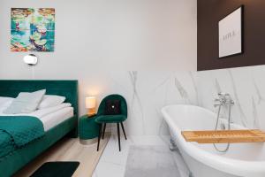 1 dormitorio con 1 cama y bañera junto a la cama en Cały apartament z Victorian wanna i podwojnym prysznicem w spokojnej dzielnicy, en Borkowo