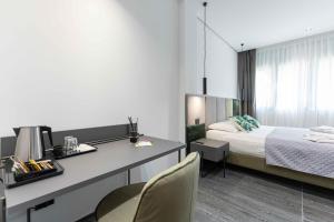 a bedroom with a bed and a desk and a bed at ML luxury room in Lido di Spina
