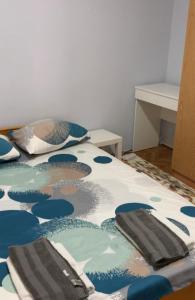 a bed with blue and white sheets and pillows on it at St. Sava Slavija Apartment in Belgrade