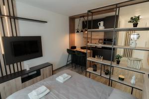 Habitación con cama, TV y habitación. en Apartman Resident, en Sombor