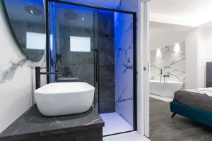 La salle de bains est pourvue d'une baignoire, d'un lavabo et d'une douche. dans l'établissement ML luxury room, à Lido di Spina