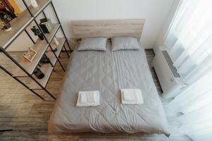 1 dormitorio con 1 cama con 2 almohadas blancas en Apartman Resident, en Sombor