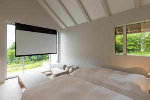 una camera bianca con un grande letto e una grande finestra di Kamosu Mori - Vacation STAY 63383v a Tsunan