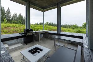 una veranda riparata con tavoli, sedie e stufa di Kamosu Mori - Vacation STAY 63383v a Tsunan