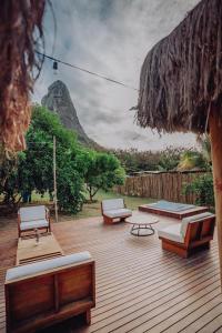 una terraza con tumbonas y bancos. en Casa Pé na Areia Noronha en Fernando de Noronha