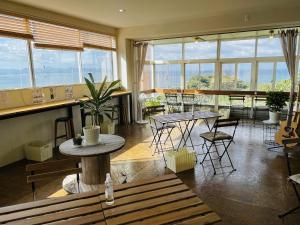 a room with tables and chairs and windows at Umi no Gohanya Noramare - Vacation STAY 18185v in Masuda