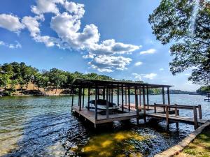 un muelle en un lago con un barco en el agua en #04-Adorable Large 1 Bedroom Lakeside Cottage- Pet Friendly, en Hot Springs