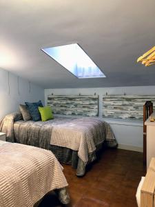 a bedroom with two beds and a skylight at Pension ILARRAZABAL in Azpeitia