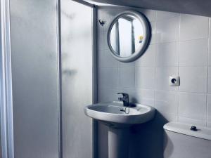 a bathroom with a sink and a shower with a mirror at Pension ILARRAZABAL in Azpeitia