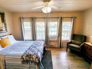 une chambre avec un lit, une chaise et des fenêtres dans l'établissement #04-Adorable Large 1 Bedroom Lakeside Cottage- Pet Friendly, à Hot Springs