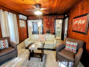 a living room with a couch and chairs and a ceiling fan at #04-Adorable Large 1 Bedroom Lakeside Cottage- Pet Friendly in Hot Springs