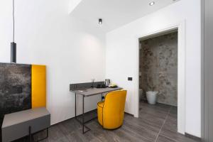 Cette chambre comprend un bureau et une chaise jaune. dans l'établissement ML luxury room, à Lido di Spina