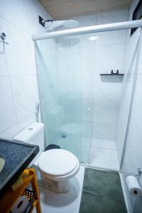 a bathroom with a toilet and a glass shower at Casa Pé na Areia Noronha in Fernando de Noronha
