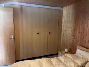 a bedroom with a bed and a large closet at Chalet Sunneggli in Adelboden