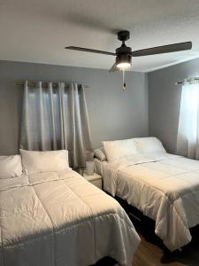 una camera da letto con due letti e un ventilatore a soffitto di 3brdrm home near Downtown Orlando and Winterpark a Orlando