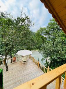 a wooden deck with a table and chairs on it at IVA House in Çamlıhemşin
