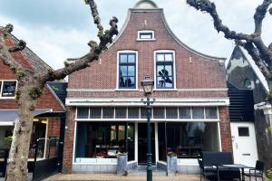 un edificio di mattoni con un lampione davanti di Schitterend appartement in dorpsstraat Langweer! a Langweer