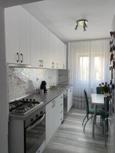a kitchen with white cabinets and a stove top oven at 514 DISTRICT in Hunedoara