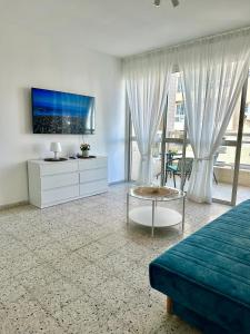 a living room with a bed and a tv at Sea breeze in Bat Yam