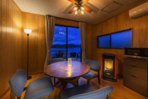 ein Esszimmer mit einem Tisch, Stühlen und einem Kamin in der Unterkunft Hermitage Resort Matsushima hibiki - Vacation STAY 14654 