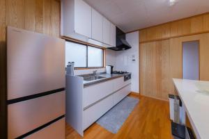 eine Küche mit weißen Schränken und einem Waschbecken in der Unterkunft Hermitage Resort Matsushima hibiki - Vacation STAY 14654 