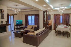 Una sala de estar con un sofá, una mesa y un televisor. en Villa Veghera, en Kissamos