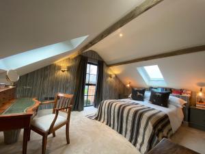 um quarto com uma cama, uma secretária e uma cadeira em Luxury Barn conversion, 3 bed, 3 bath with hot-tub em Bedford