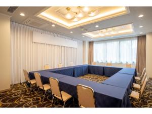 Misawa City Hotel - Vacation STAY 81764v في ميساوا: قاعة اجتماعات كبيرة مع طاولة وكراسي زرقاء
