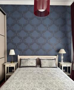 a bedroom with a bed and a blue wall at Vilnius street apartment in Vilnius