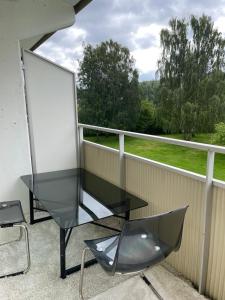 a glass table and a chair on a balcony at Tway luxury homes in Jönköping