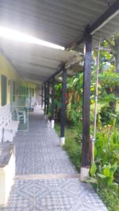 a hallway of a building with benches and plants at Pousada Lambaris Pereque Guarujá in Guarujá