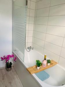 a bathroom with a bath tub with a shower and plants at cocooning modern design studio in Avesnes-sur-Helpe