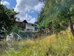 una casa sul fianco di una collina con erba alta di Nebanauer a Kappl
