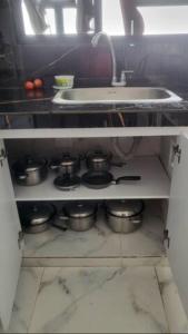 una cocina con ollas y sartenes en un estante bajo un fregadero en Bello apartamento familiar en Pitalito, en Pitalito