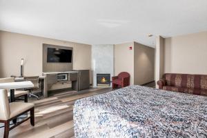 una camera d'albergo con letto, scrivania e camino di Horizon Inn ad Avenel