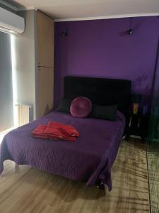 Dormitorio púrpura con cama con sábanas púrpuras en Alto Nqn en Neuquén