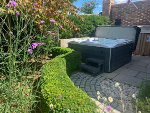 un jardín con bañera en un patio en Luxury Barn conversion, 3 bed, 3 bath with hot-tub en Bedford