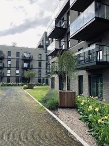 a building with a tree in the middle of a driveway at Motlawa Inn Apartment-Suna,Gym&Parking in Gdańsk