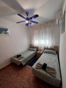 a bedroom with two beds and a ceiling fan at Great Sun Terrace Close to Beach in Gran Alacant