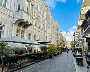 eine Stadtstraße mit Tischen, Stühlen und Gebäuden in der Unterkunft Vilnius street apartment in Vilnius