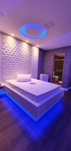 a bedroom with a large bed with a blue lighting at Motel Fantasy 3 (Adult Only) in Belo Horizonte