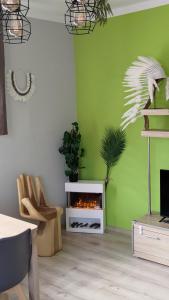 een woonkamer met een open haard en een groene muur bij Stylowy apartament w Gdyni z bezpłatnym parkingiem i niedaleko plaży in Gdynia