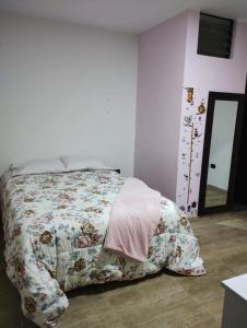 a bedroom with a bed with a floral bedspread at Casa de Juli in Huancayo