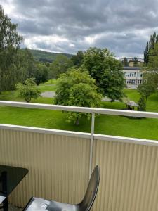 a chair on a balcony with a view of a park at Twayi Luxury Suites in Jönköping