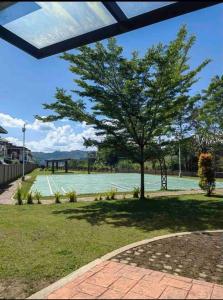 un albero seduto sopra un campo da tennis di 3 Bedroom Furnished House near SM CDO uptown a Cagayan de Oro